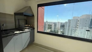 Une cuisine moderne dotée d’une grande fenêtre, d’une cuisinière et de placards.