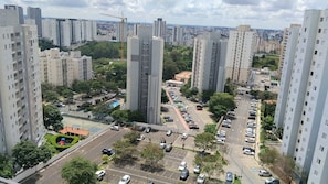 A high-rise residential area with multiple apartment buildings, a parking lot, and a construction crane in the distance. - Studio in a Sought After Location (Sorocaba)
