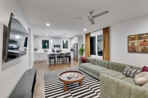 A modern living room with a sofa, a coffee table, and a striped rug.