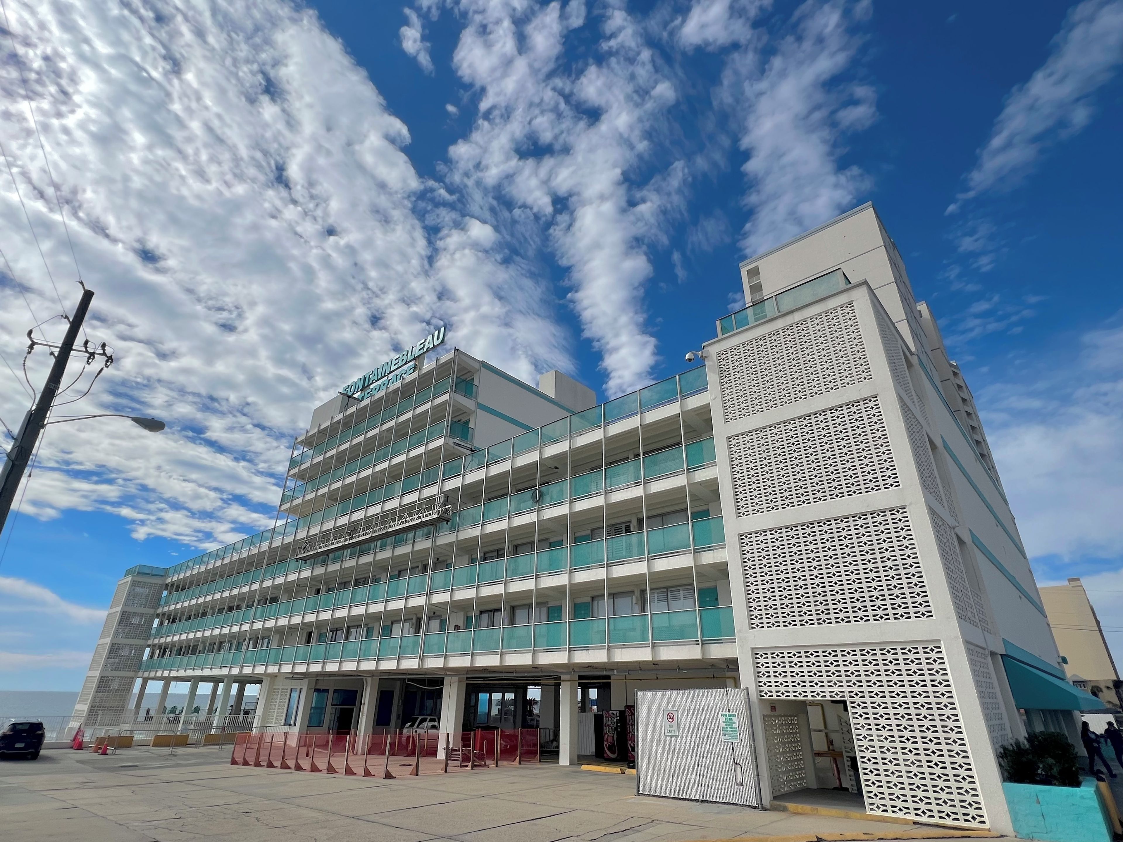 Un hôtel à plusieurs étages, doté d’une architecture moderne, avec des balcons et une entrée imposante.