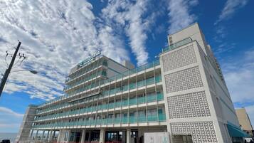 Un hôtel à plusieurs étages, doté d’une architecture moderne, avec des balcons et une entrée imposante.
