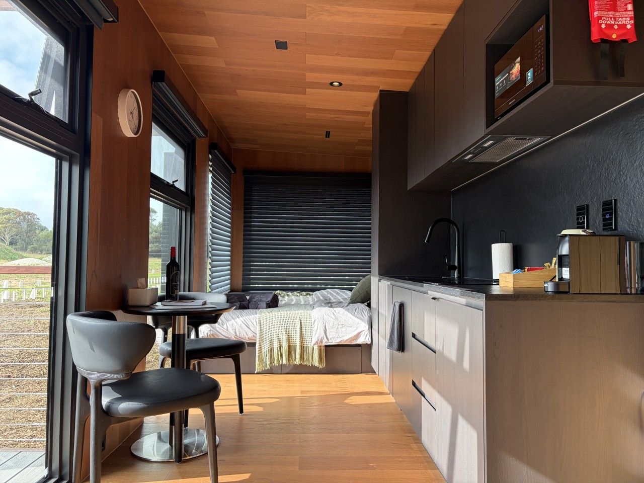 Une cuisine compacte avec un coin repas, un lit et une vue sur l’extérieur.