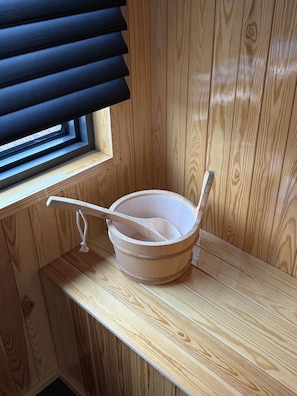 En træsauna med et træbadekar og en træske, der ligger ovenpå.