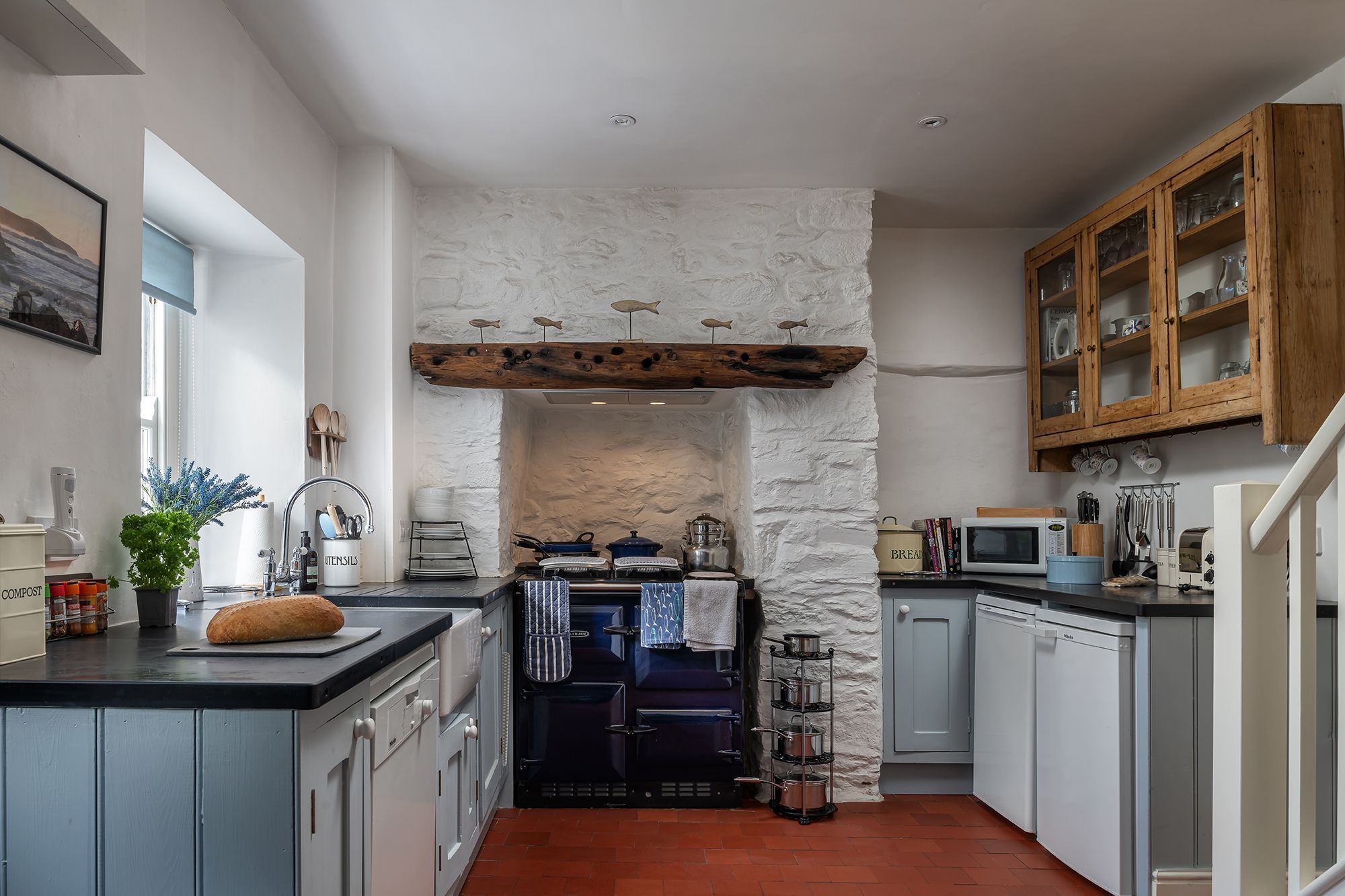 A kitchen with a stone wall, wooden cabinets, and a built-in oven.