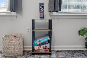Una estantería con una caja de JUMBLING TOWER y libros infantiles.