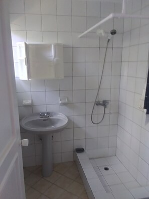 A small bathroom with a sink, a shower, and a toilet. -  Encuentro Beach hidden gem / 1 Br, a/c, Internet, pool, backup electricity (Cabarete)