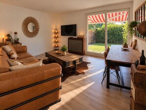 A living room with a sofa, a coffee table, a TV, and a dining area with a table and chairs. - Beautiful 3 bdr villa close to CDG airport/ villepinte/ Paris (Aulnay-sous-Bois)