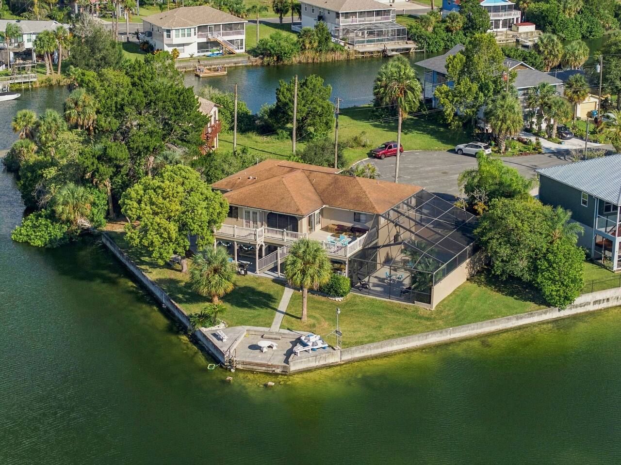 A waterfront property with a large house, a dock, and a boat.