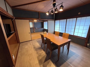 Una tradizionale stanza in stile giapponese, con pavimento in tatami, un tavolino e porte scorrevoli.
