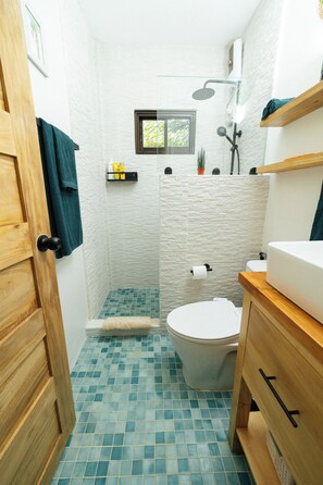 Un baño con ducha, inodoro y lavabo.