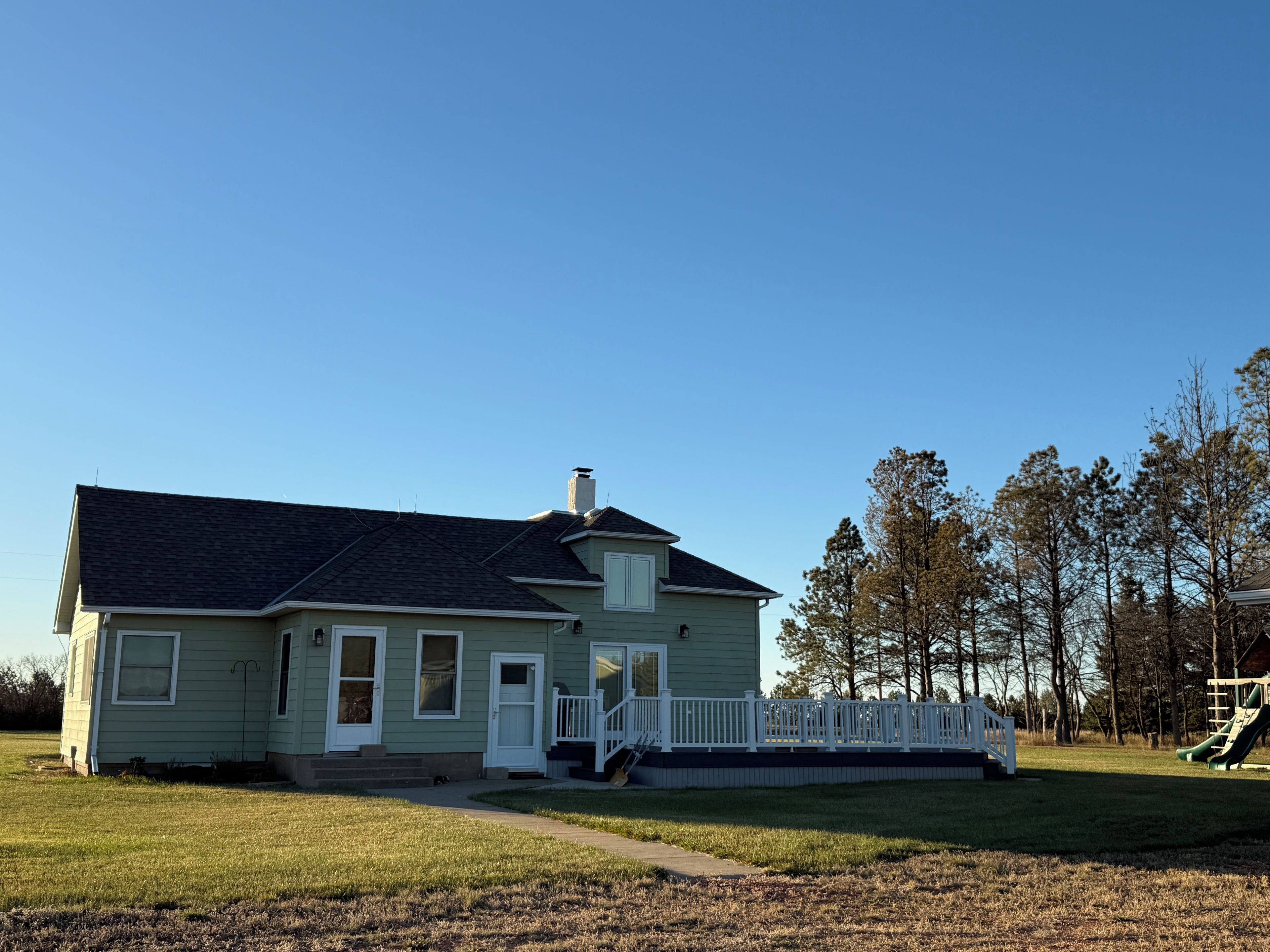 A single-story house with a front porch and a fenced yard.