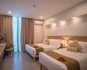 A hotel room with two beds, a desk, and a chair. - Galilea Hotel Bohol (Tagbilaran)