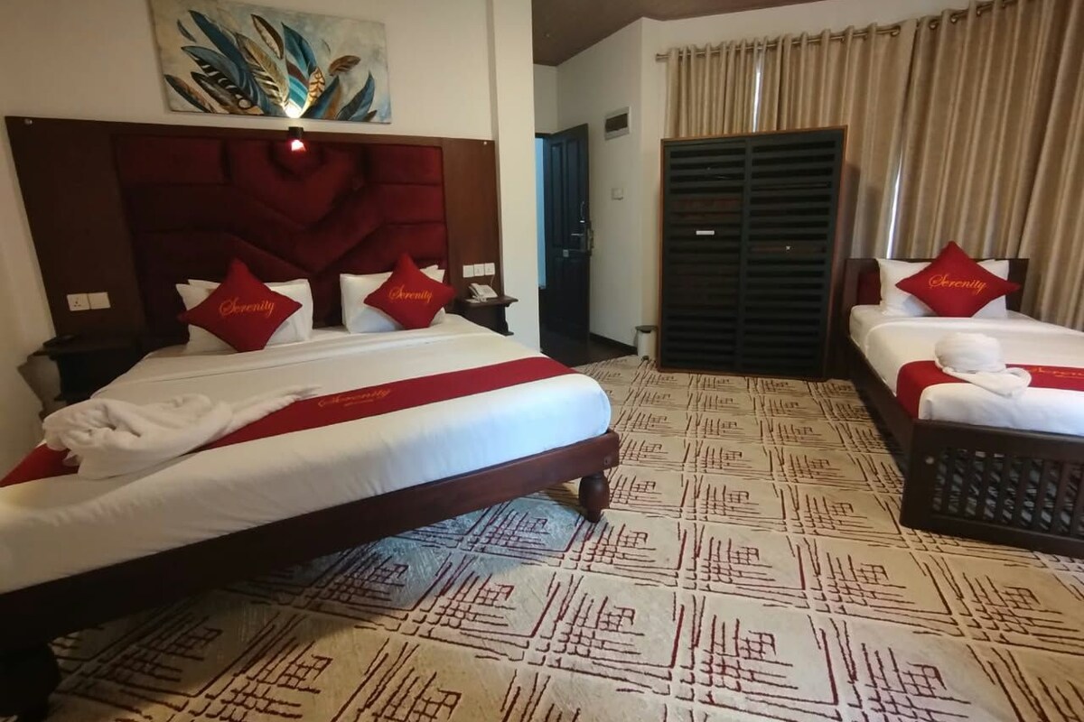Quarto de hotel com duas camas, cabeceira vermelha, carpete estampado e um quadro na parede.