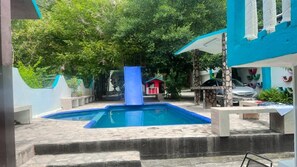 A swimming pool with a blue cover, surrounded by a stone patio. - New Listing (Santiago)