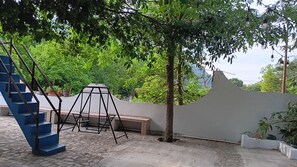 A courtyard with a swing set, a bench, and a staircase. - New Listing (Santiago)