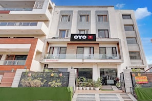 Un edificio de varios pisos con un letrero que indica 'OYO Stay', identificándolo como un hotel.