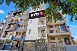 A multi-story hotel building with balconies and a sign indicating it is a hotel. - Hotel O Premier Stays (Gurugram)