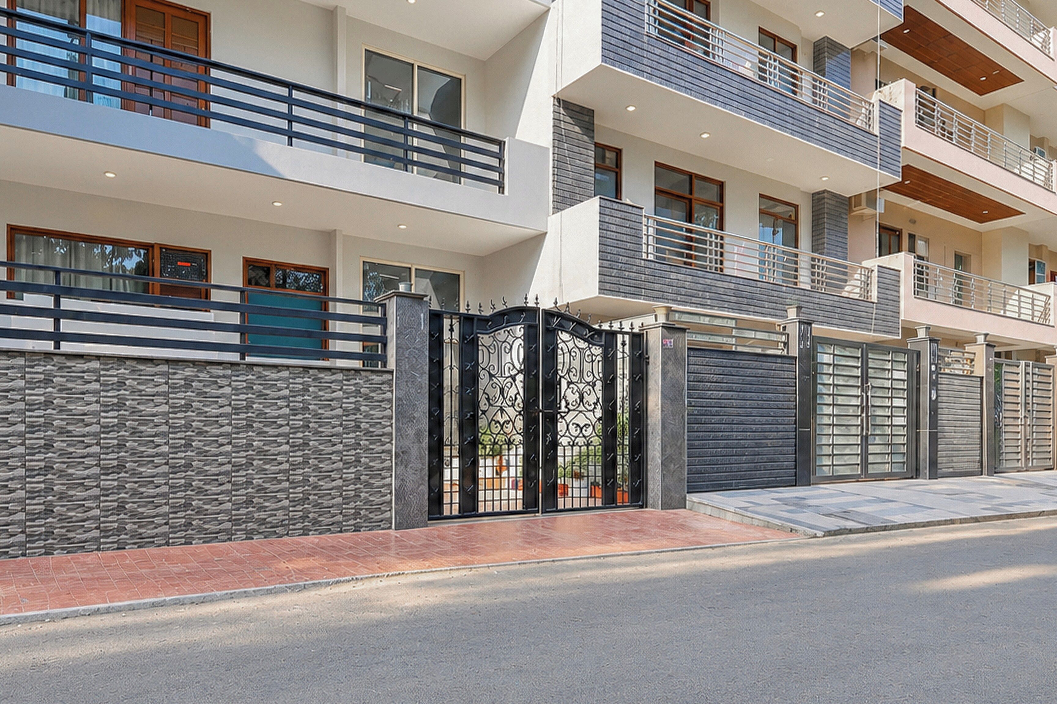 Un immeuble résidentiel à plusieurs étages, doté d’une entrée sécurisée par un portail, de balcons et d’une façade en pierre.