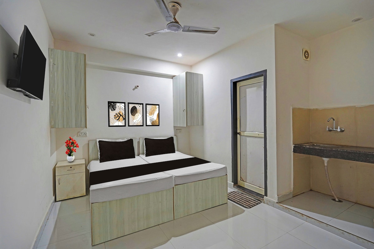 A bedroom with a bed, bedside table, and a wall-mounted TV.
