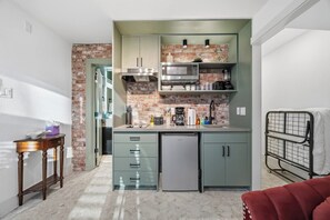 A compact kitchen with a refrigerator, microwave, and coffee maker. - SoHo Vibes - EaDo Lofts #1 (Houston)