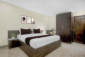 A modern bedroom with a large bed, a wardrobe, and a nightstand with a plant. - Hotel O by OYO Cdr Grand (Guntur)