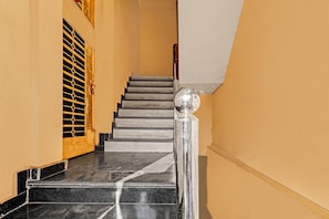 A staircase with marble steps and a metal handrail, leading to an upper floor. - Hotel O Royal (Gwalior)