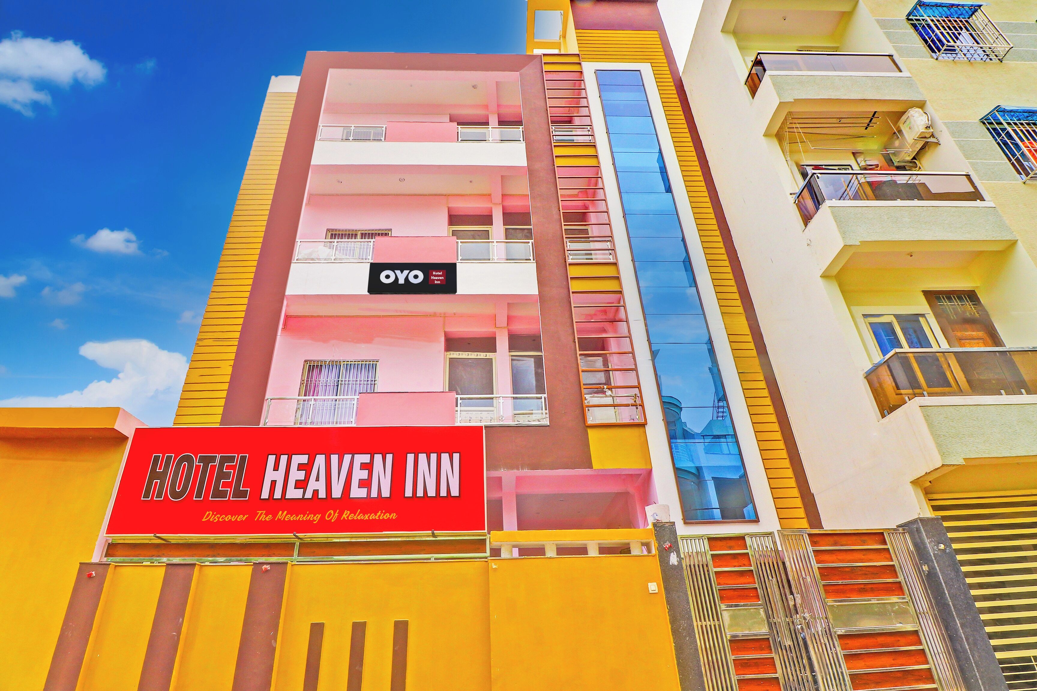 A multi-story hotel building with balconies and a prominent red sign for Hotel Heaven Inn.