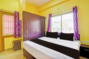 Un dormitorio con cama, cortinas, armario y ventana.