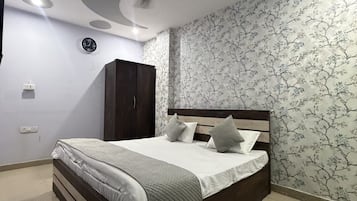 Un dormitorio con cama, armario, ventilador de techo y un reloj de pared.