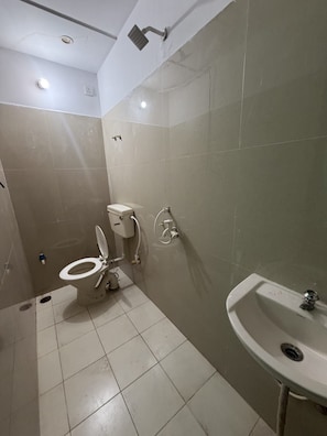 A bathroom with a toilet, bidet, and sink. - Hotel PRAGATI INN (Kanpur)