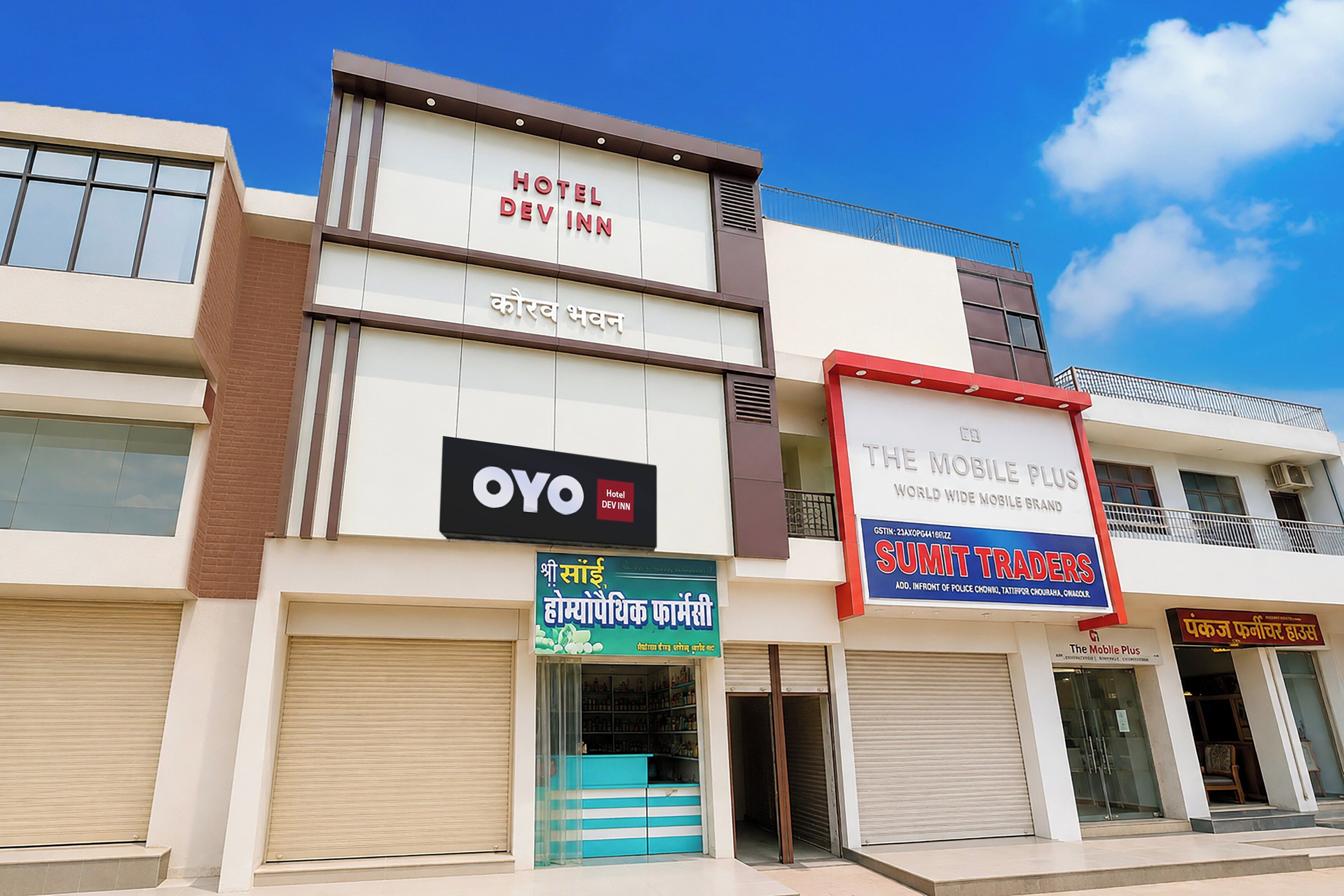 Un hotel con un cartel de Hotel Dev Inn y la marca de teléfonos móviles OYO.