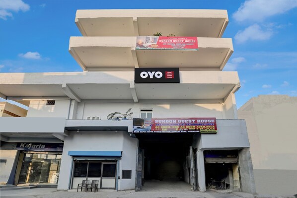 A building with multiple signs advertising Sukoon Guest House, including AC and non-AC room availability. - Hotel O Sukoon Guest House (Modinagar)