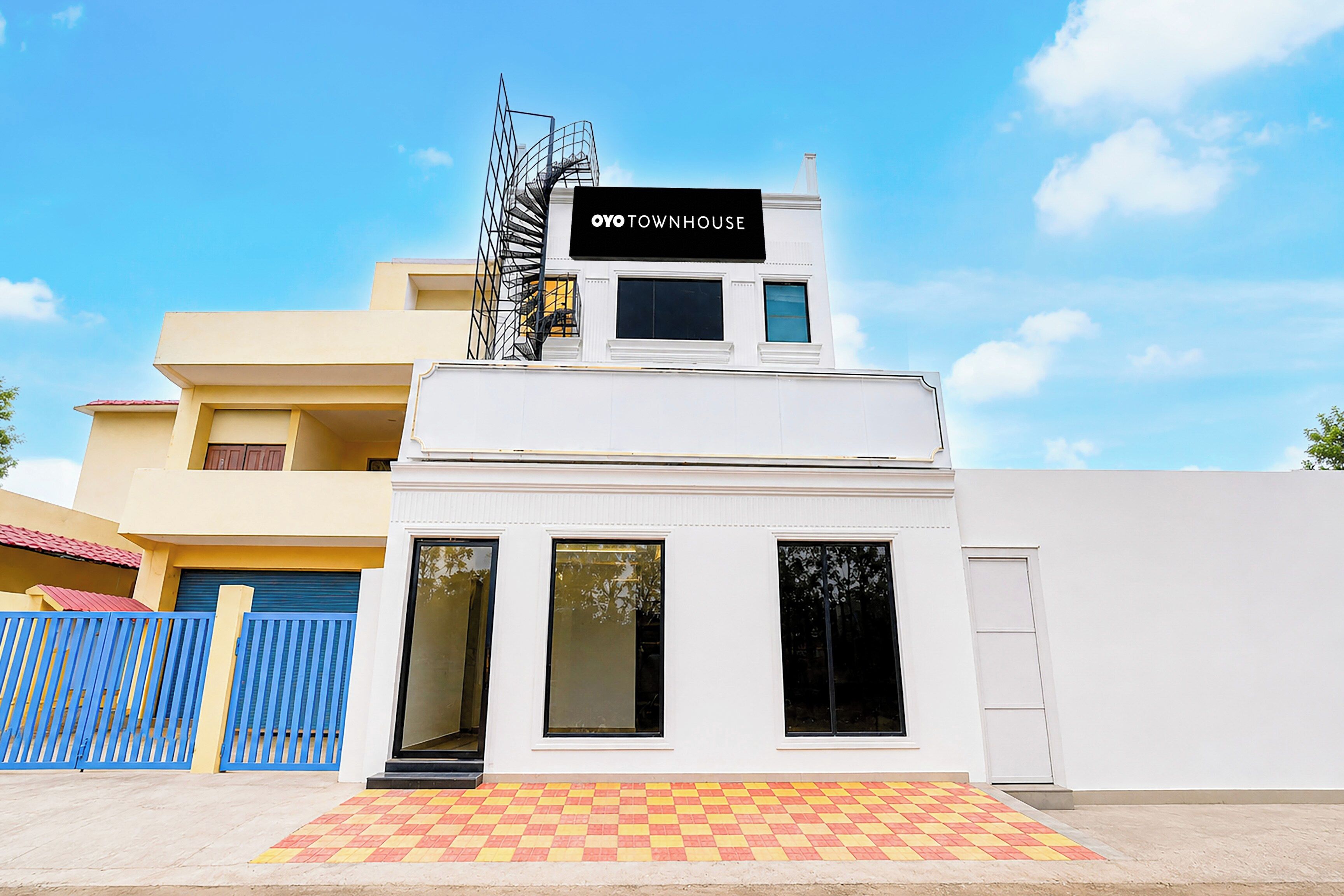 A two-story building with a sign that reads 'TOWNHOUSE' on the top.