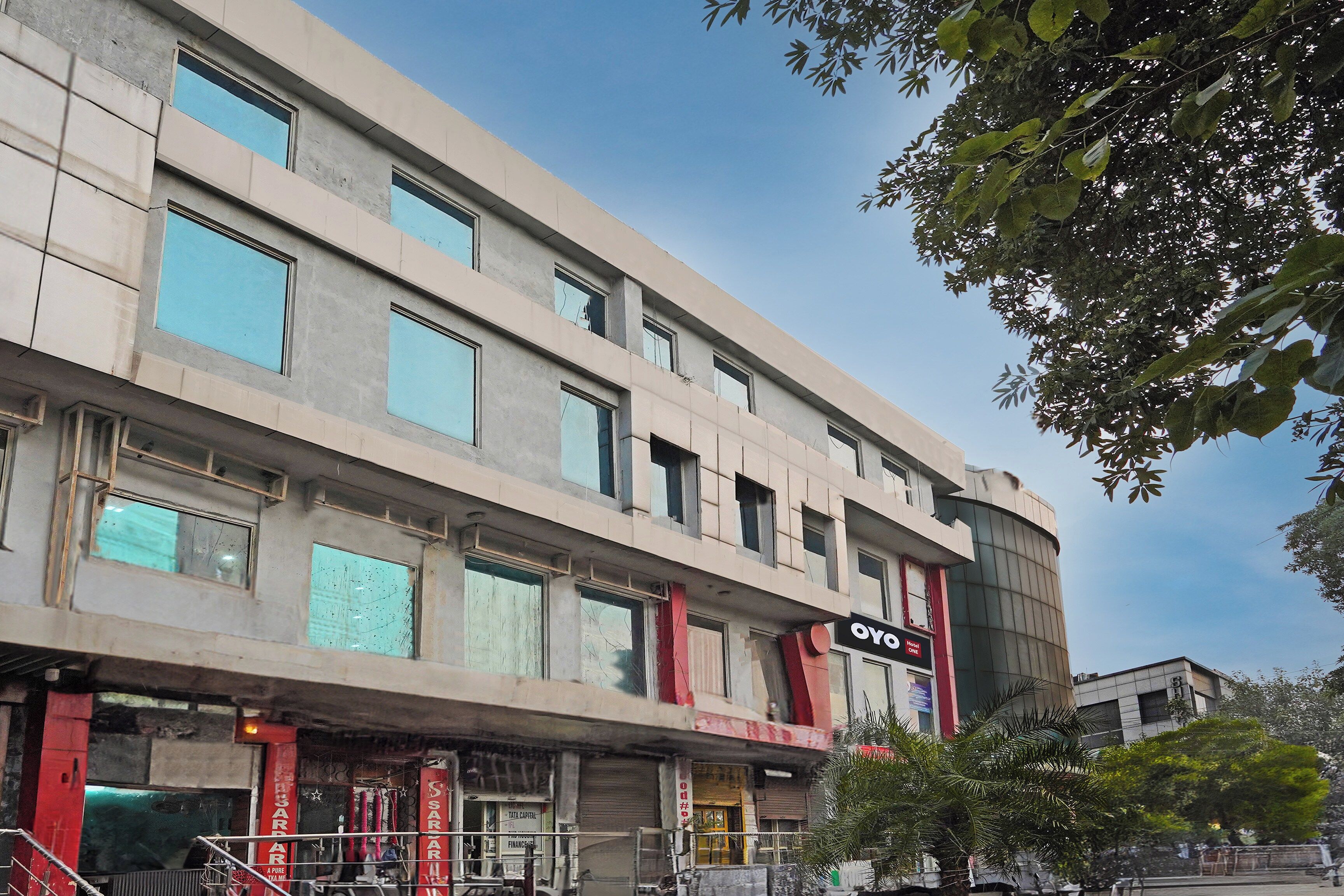 A multi-story hotel with a flat facade, large windows, and a sign for 'OYO Hotel One'.