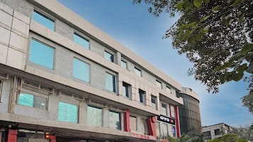 A multi-story hotel with a flat facade, large windows, and a sign for 'OYO Hotel One'.