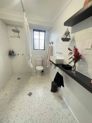 Un baño con ducha, inodoro y lavabo.