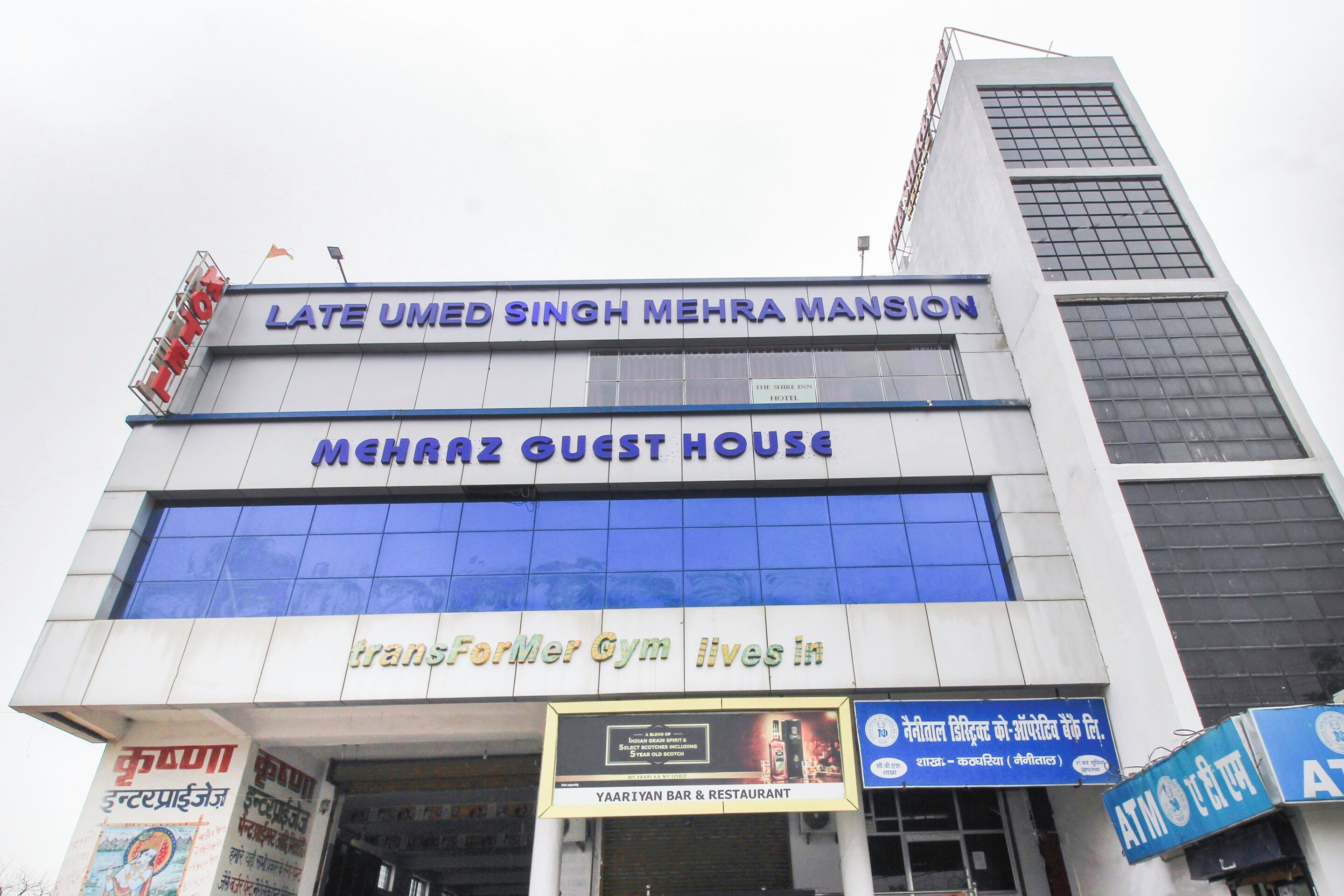 Ein Hotel mit einem Schild, auf dem 'LATE UMED SINGH MEHRA MANSION' und 'MEHRAZ GUEST HOUSE' über dem Eingang steht.