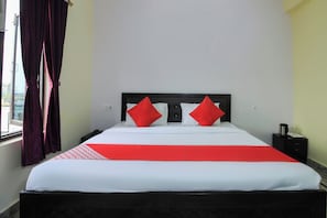 A hotel room with a bed, a nightstand, a window with curtains, and a view of the outside. - Collection O Mehraz Residency (Haldwani)