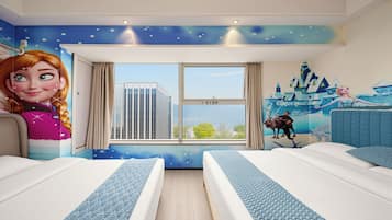 Habitación de hotel con dos camas, un ventanal con vistas a la ciudad, un mural con un personaje en la pared y un techo con diseño de estrellas.