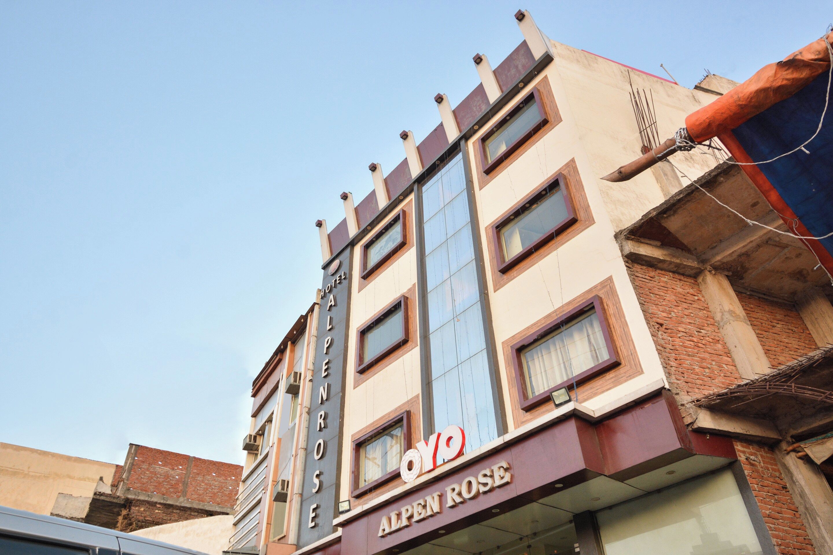 Un edificio de hotel de varios pisos con un letrero llamativo que dice 'Hotel Alpenrose'.