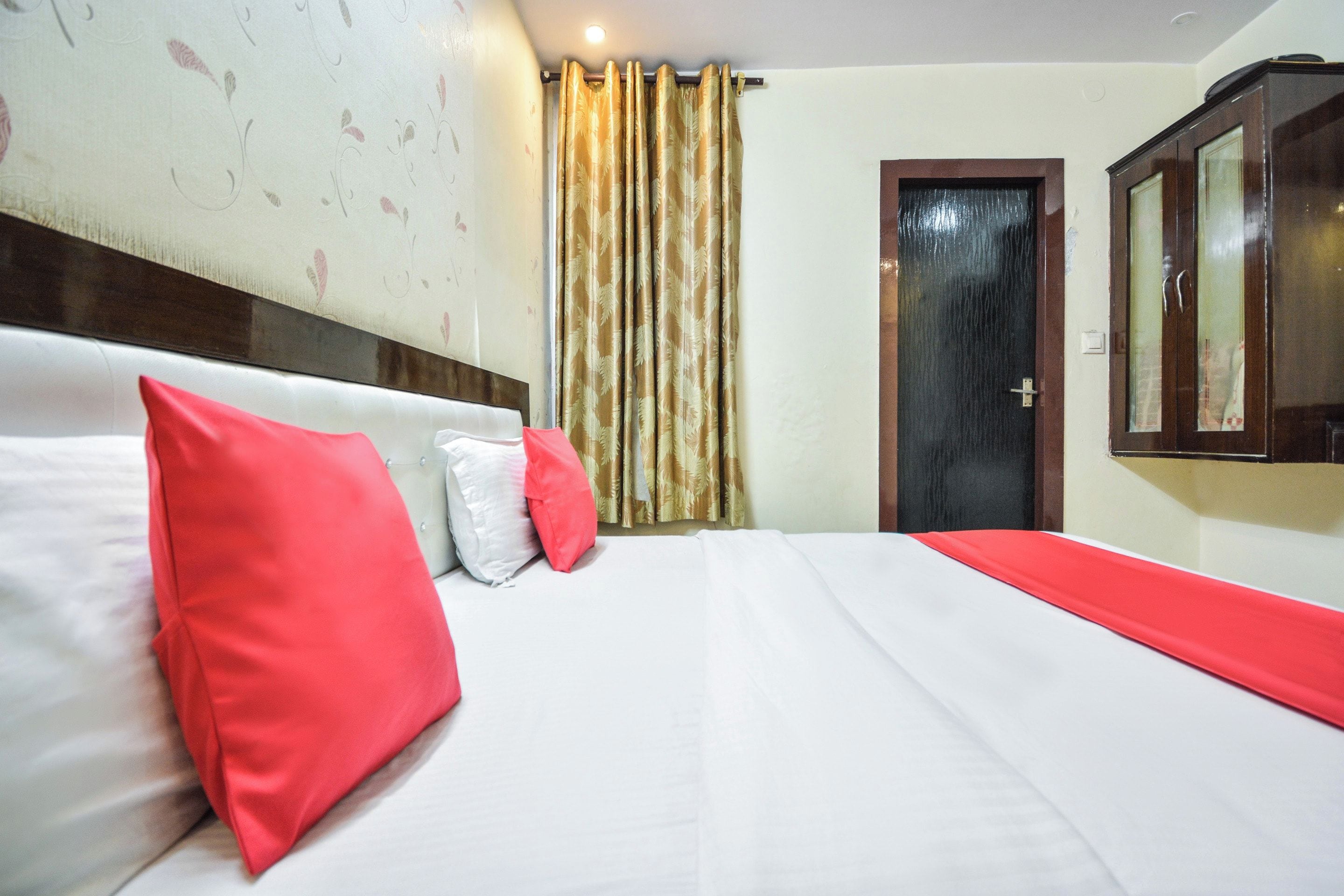 Een hotelkamer met een bed, een deur en een spiegel.