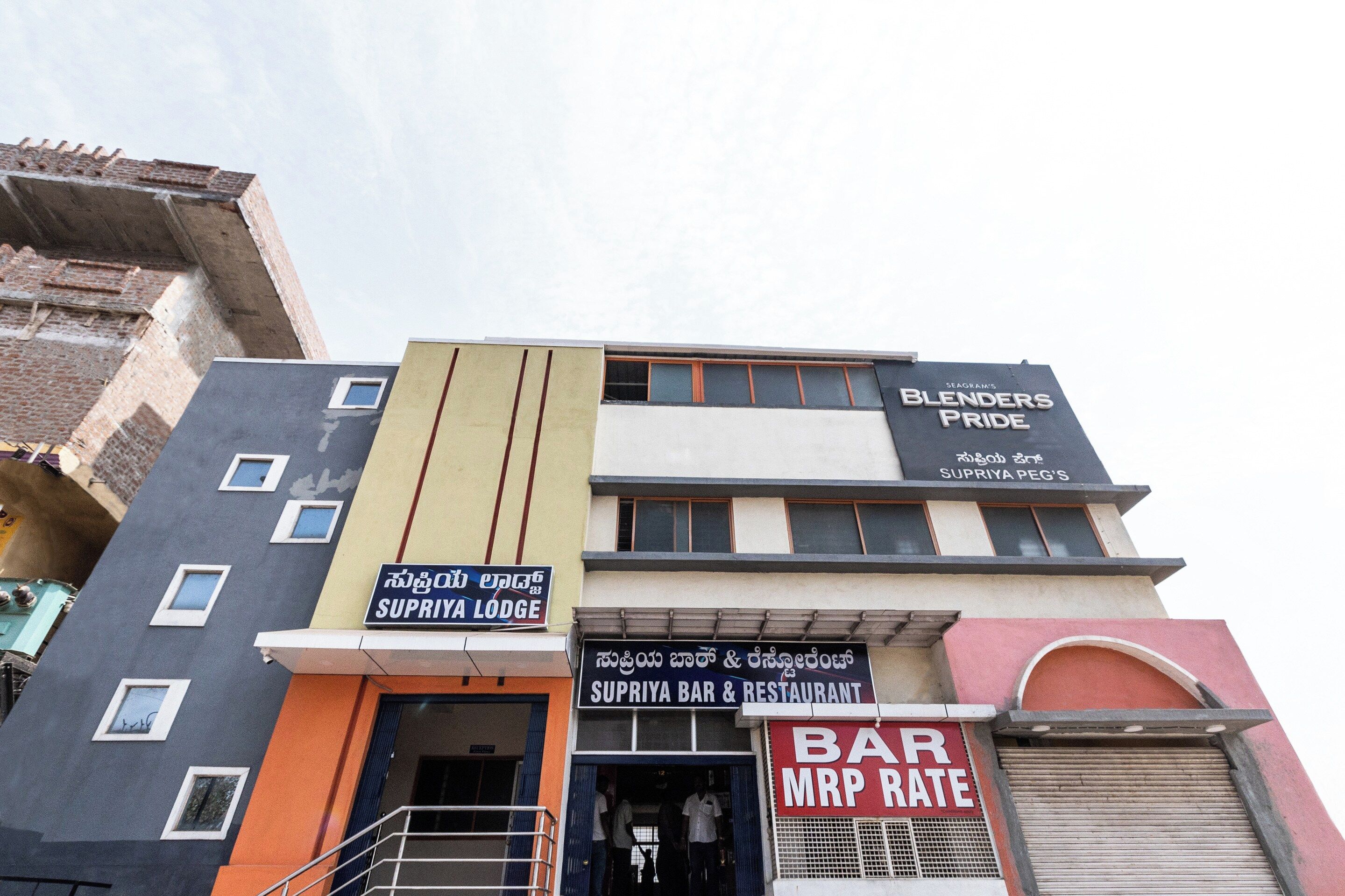 Un edificio de varios pisos con diversos comercios, incluyendo un bar, un restaurante y una posada.