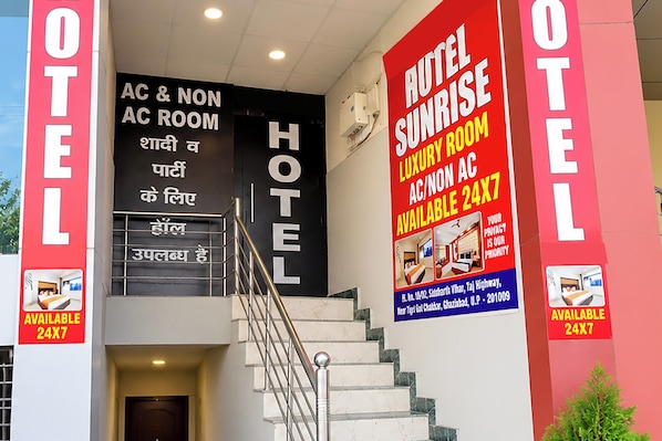 Entrada de hotel con una escalera que lleva a las habitaciones con y sin aire acondicionado.