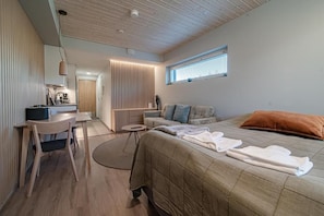 A modern bedroom with a bed, bedside tables, a desk, and a window. - Cosy apartment for two near by West and South slopes! (Kittilä)