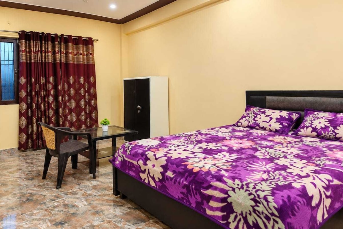 A bedroom with a bed, a desk, and a chair.