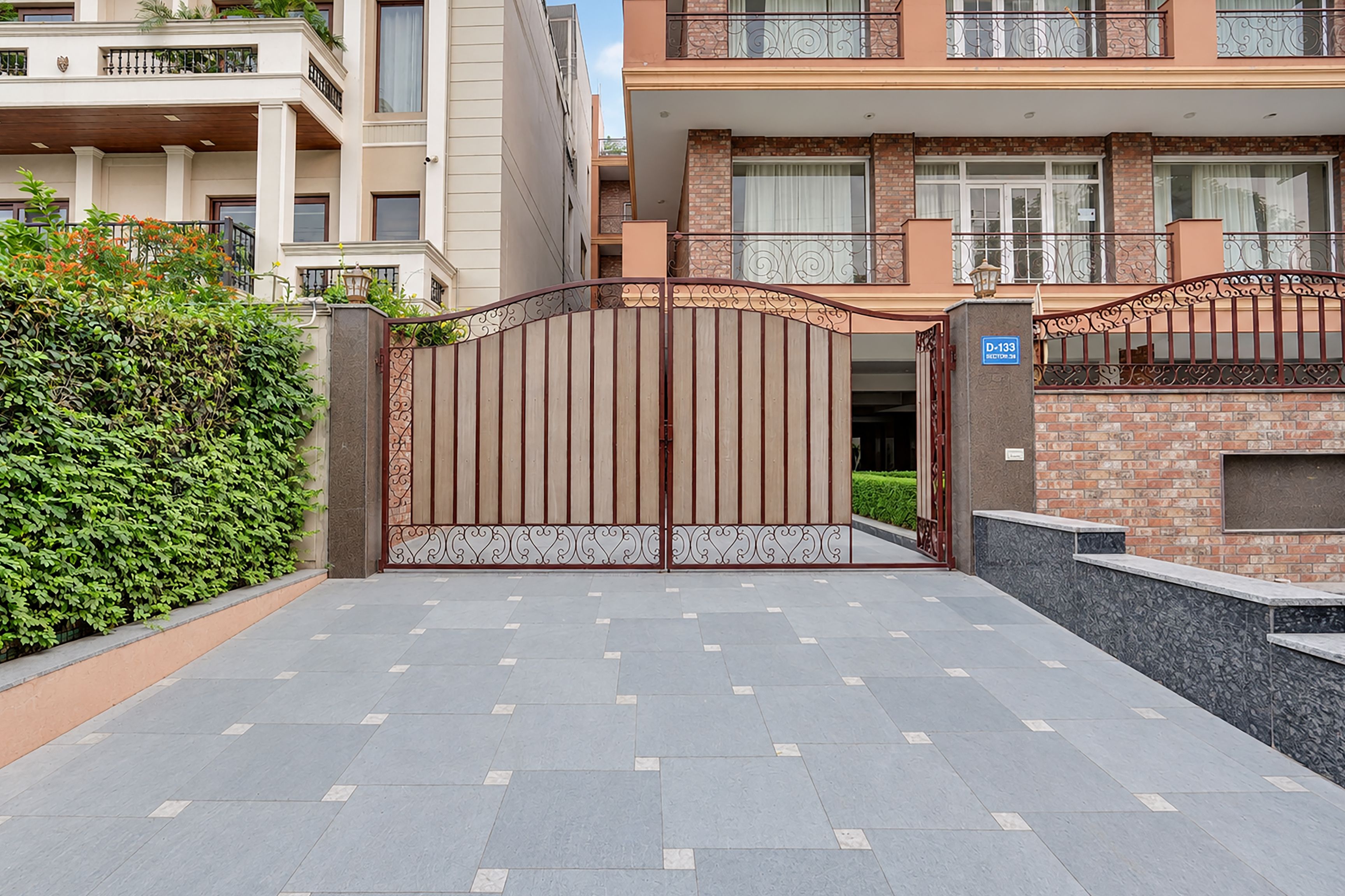 A gated entrance to a residential building with a paved driveway.