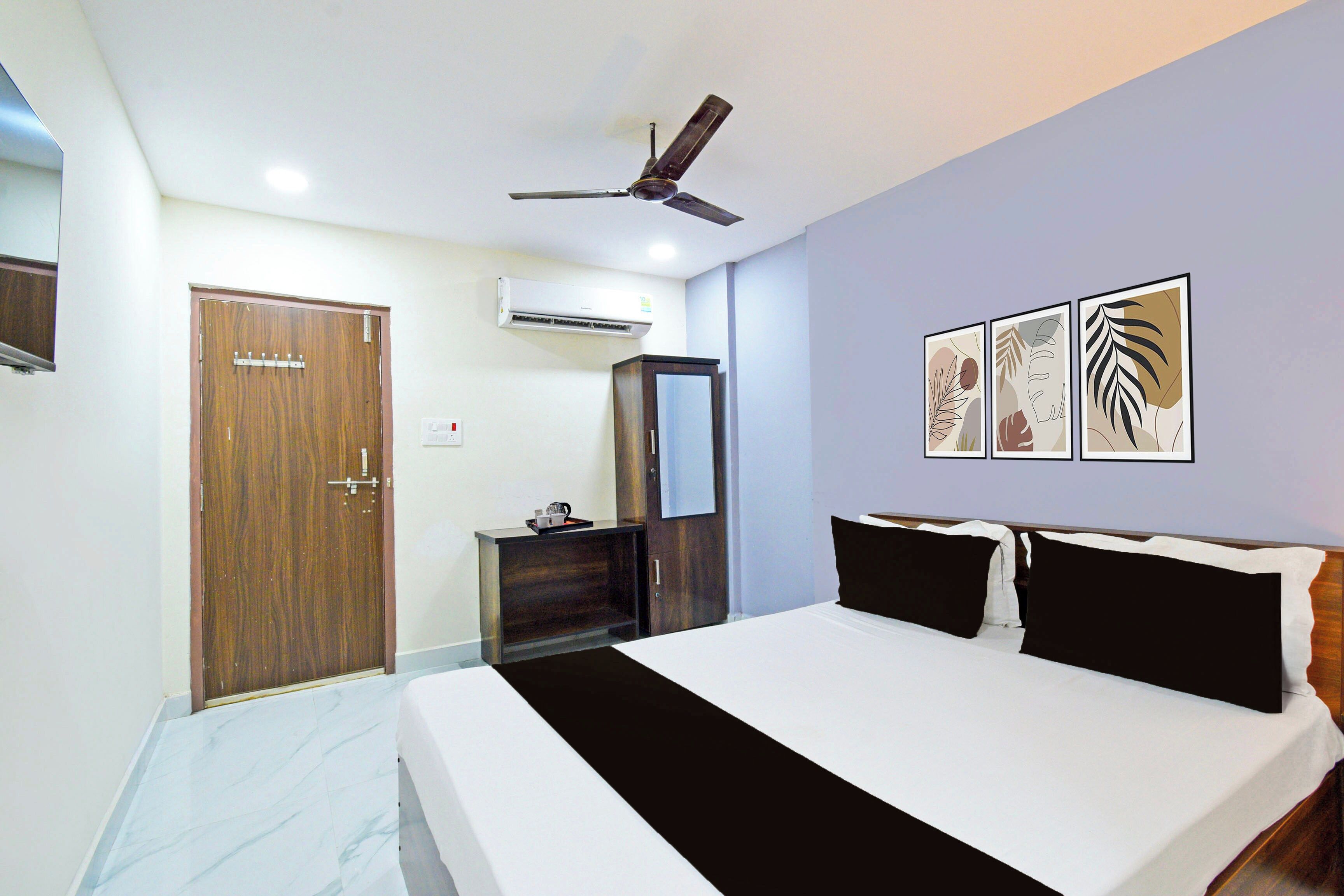 Un dormitorio con cama, armario, espejo, aire acondicionado y ventilador de techo.
