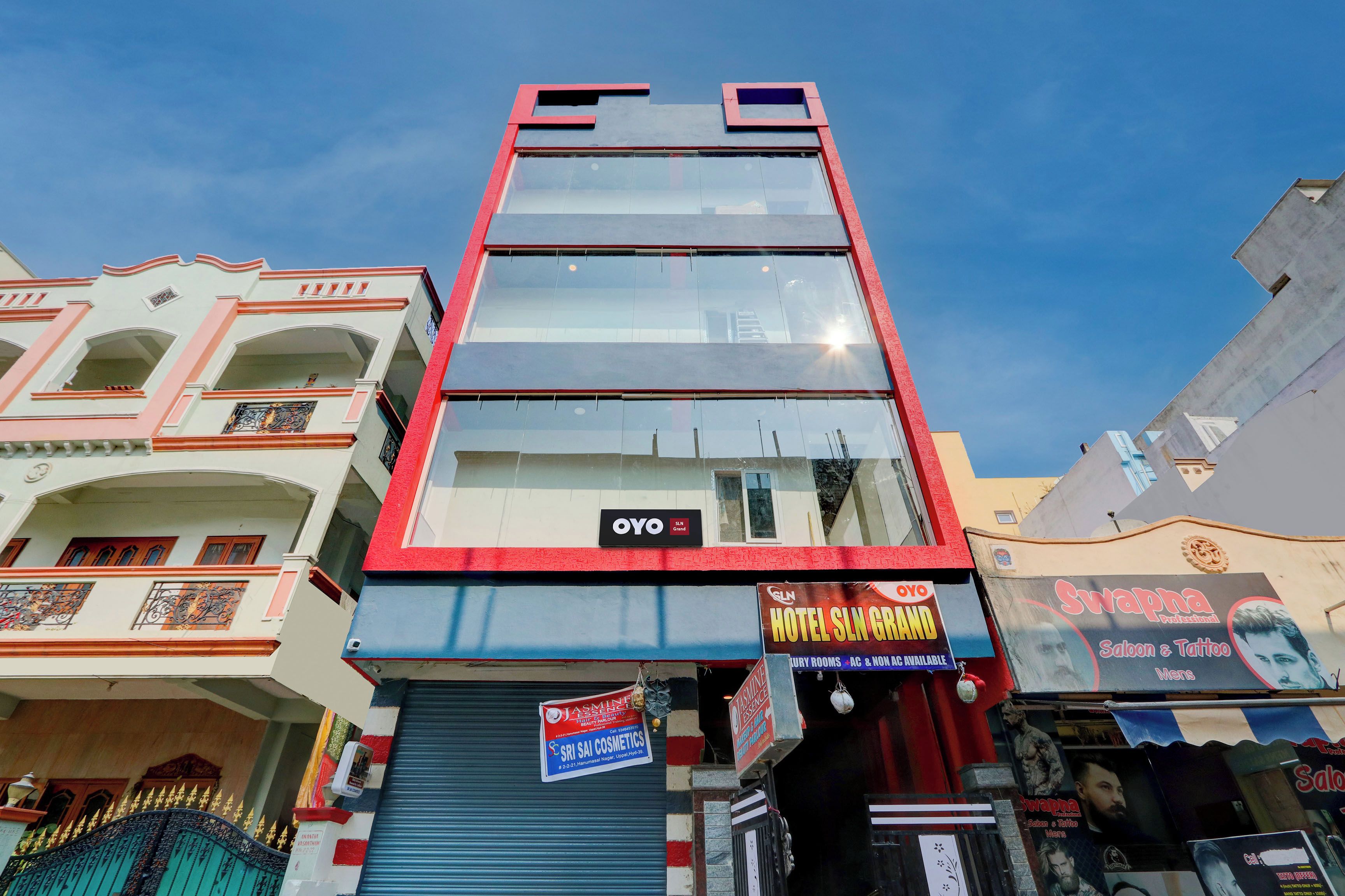 A multi-story hotel with a modern facade, featuring large glass windows and a prominent red and white color scheme.