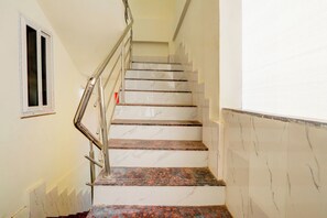 A staircase with a metal handrail and marble steps. - Hotel O by OYO S L N Grand (Hyderabad)