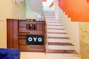 A reception area with a wooden reception desk and a sign that reads 'RECEPTION.' - Hotel O by OYO S L N Grand (Hyderabad)